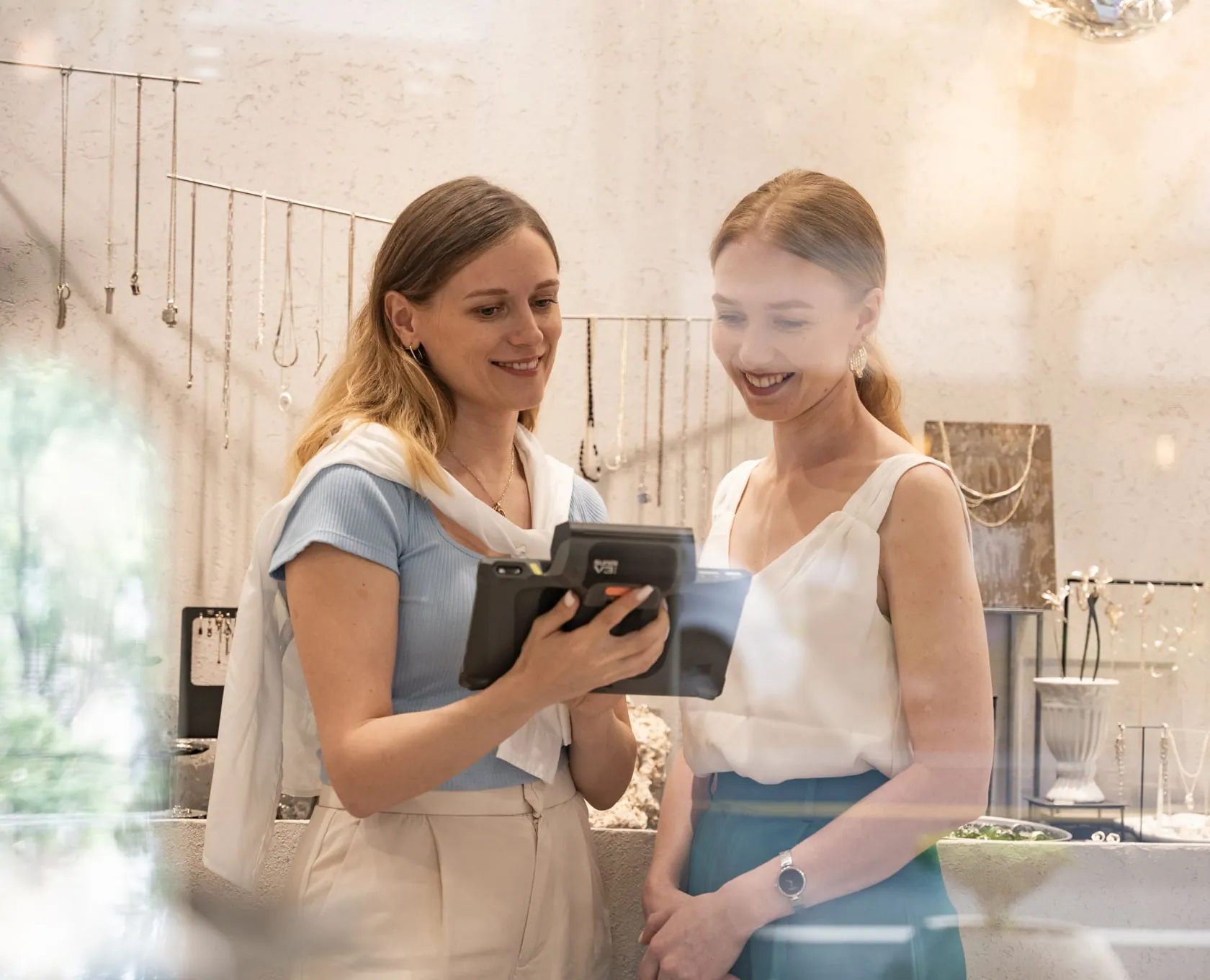 Vendeuse présentant le terminal mobile à une cliente en boutique